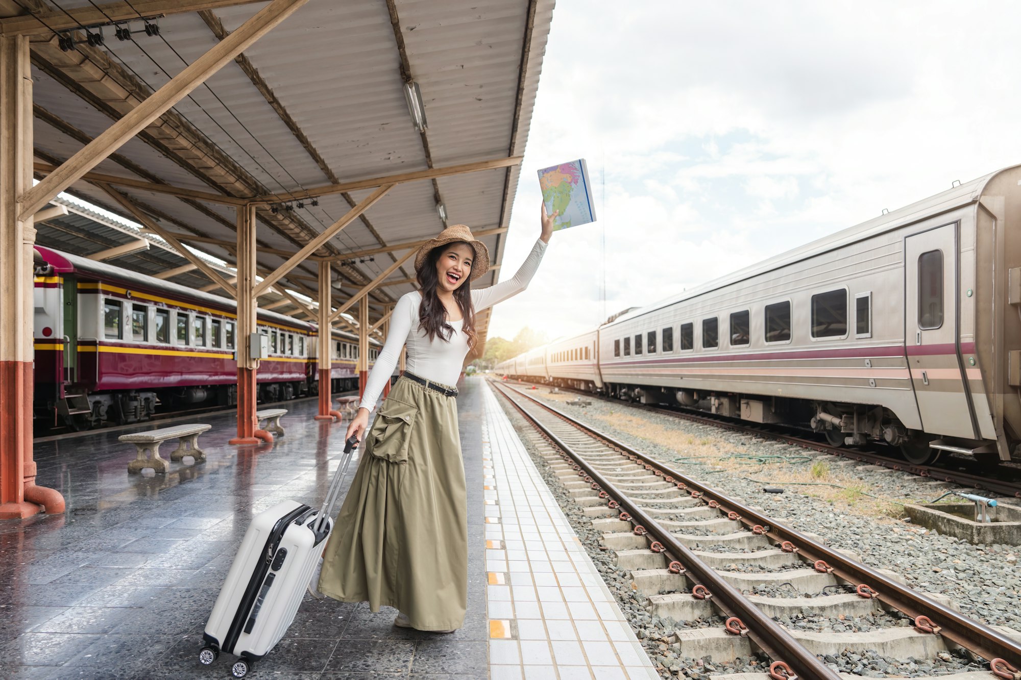 Asia woman traveller feeling happy go to travel and waiting for the on coming train at the train